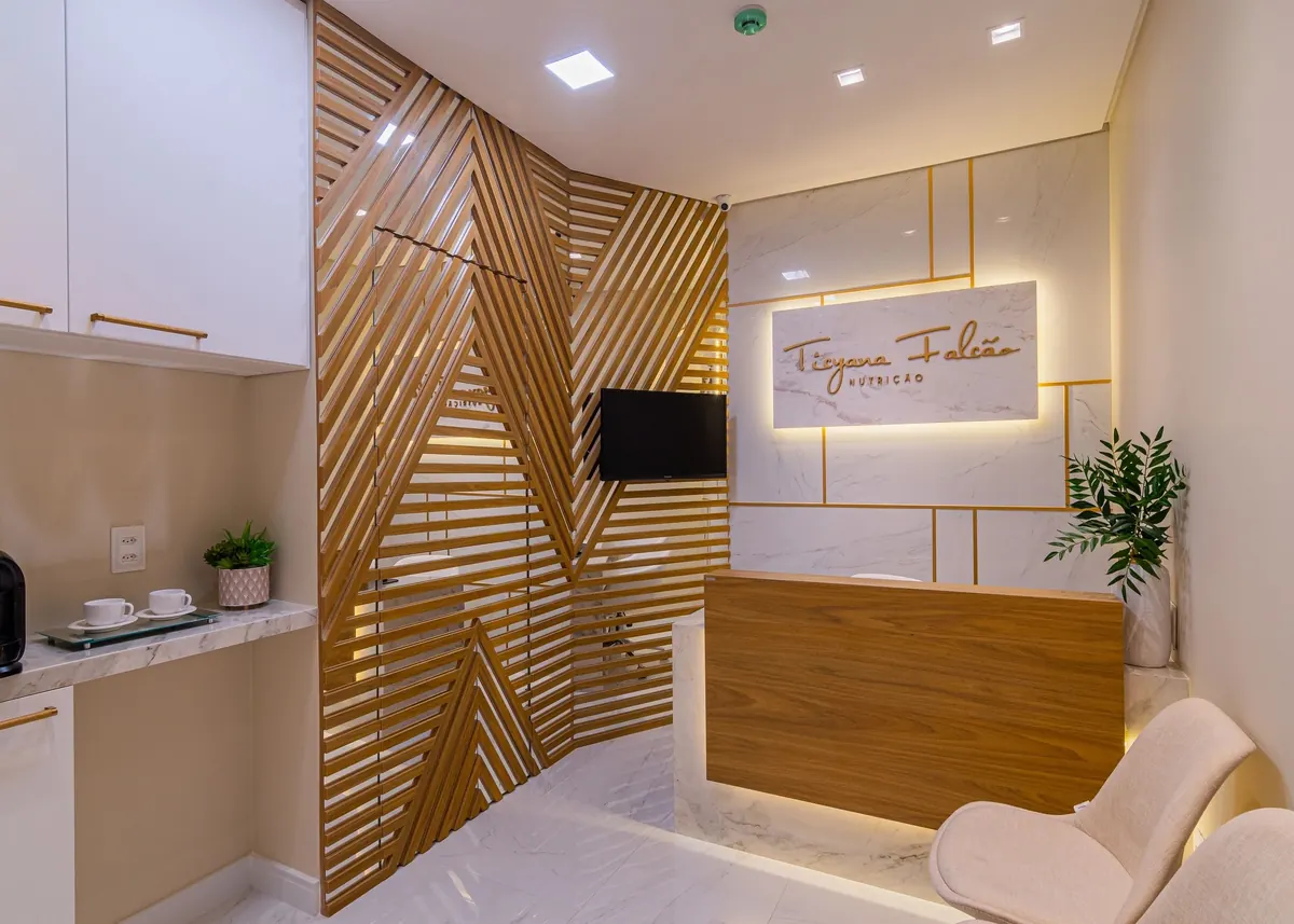 Recepção de clínica com painel ripado e iluminação embutida