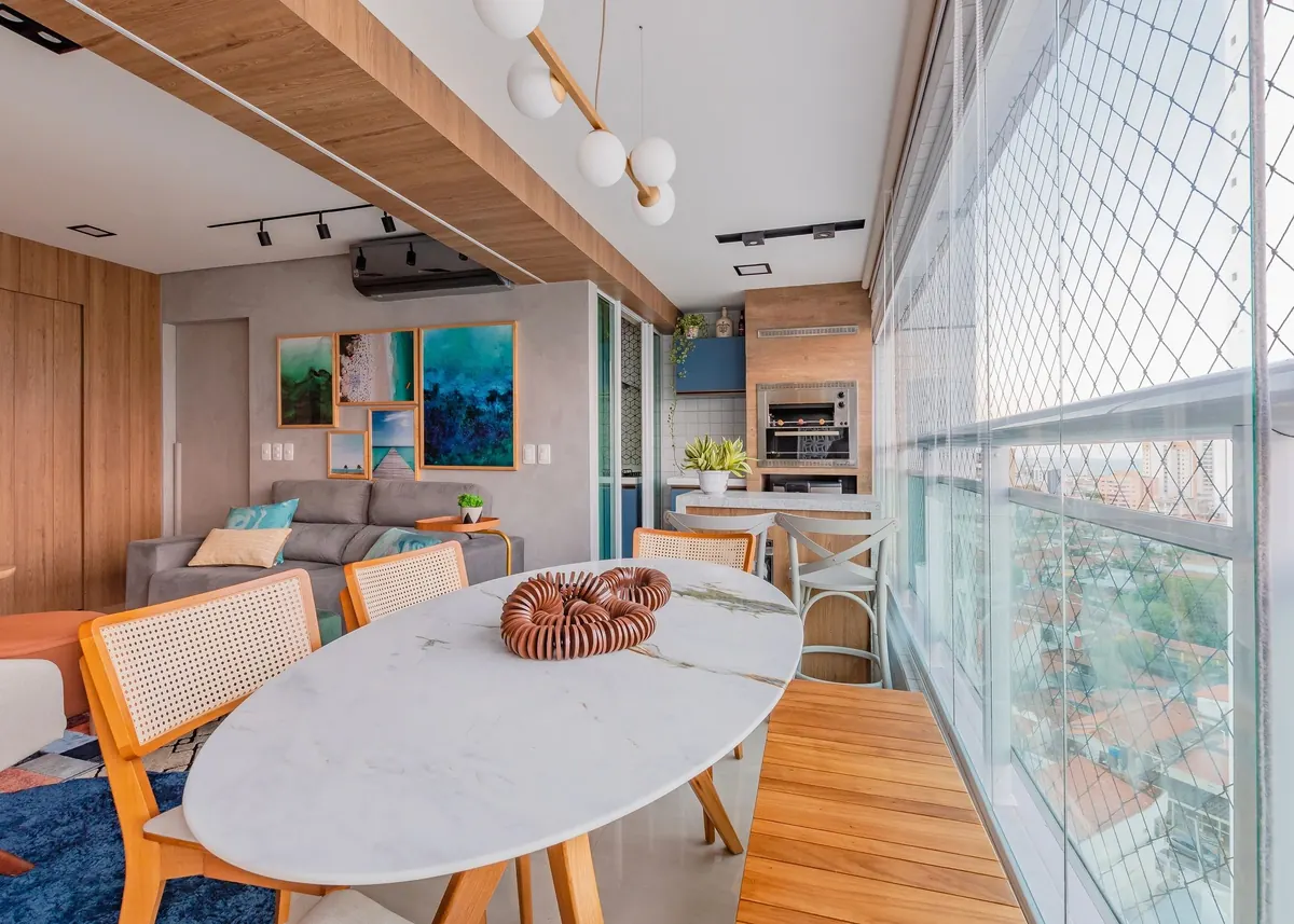 Sala de jantar com mesa oval e painel de quadros ao fundo